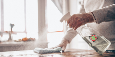 worker sanitizing table with Safe From Spread squirt bottle